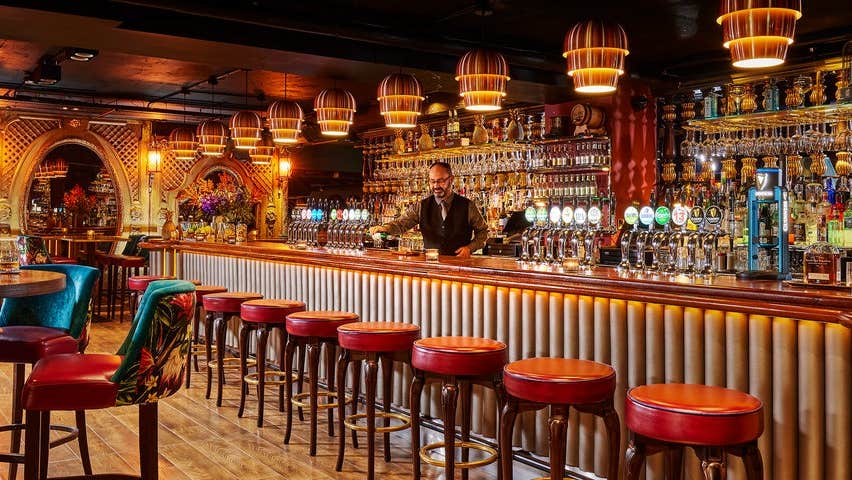 Barman pouring a drink at the bar in Bartleys