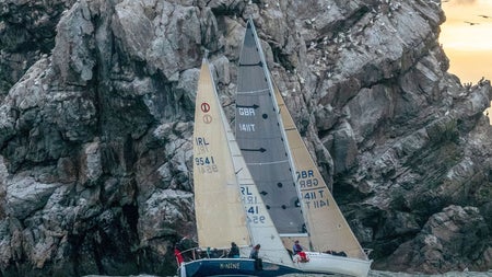 Sailing boat by the sea cliffs