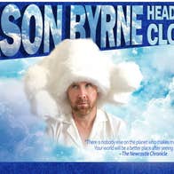 A man wearing a very large fluffy wooly hat and white shirt, surrounded by white clouds in blue sky