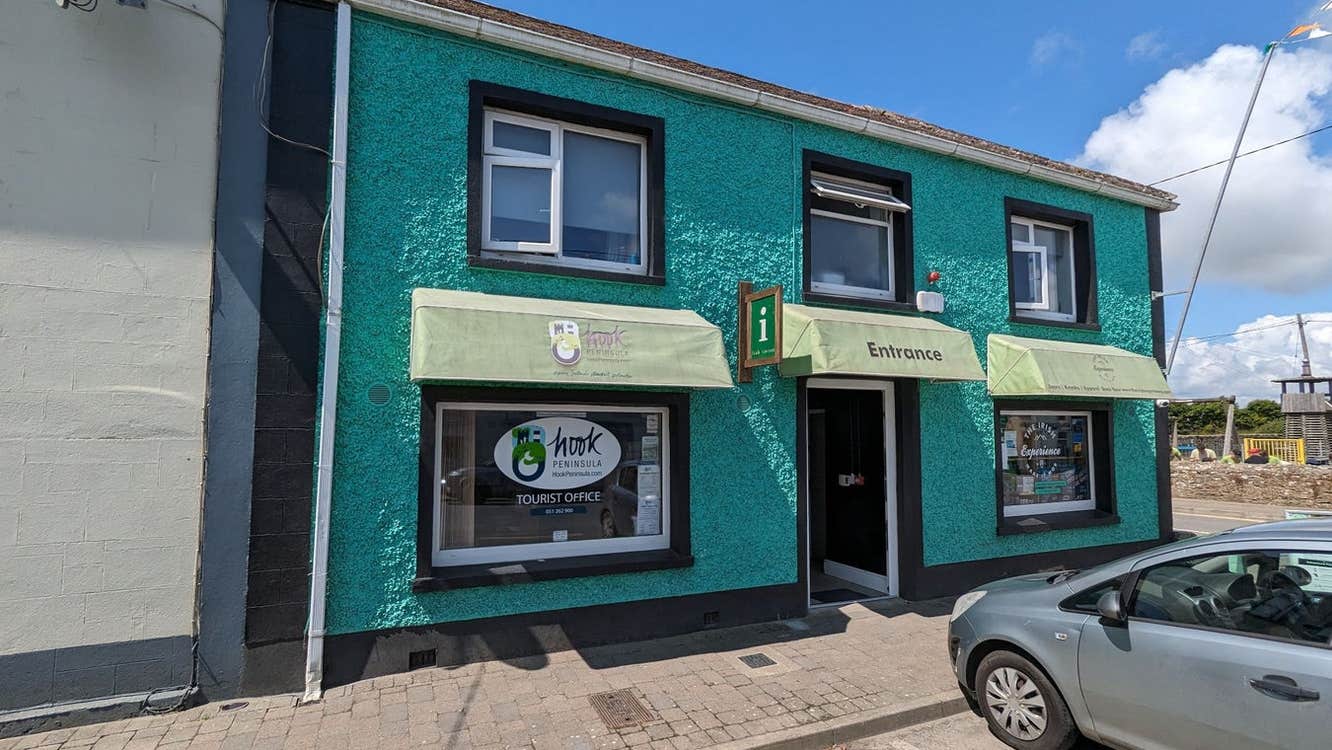 Exterior of a two storey building with an information sign on the wall