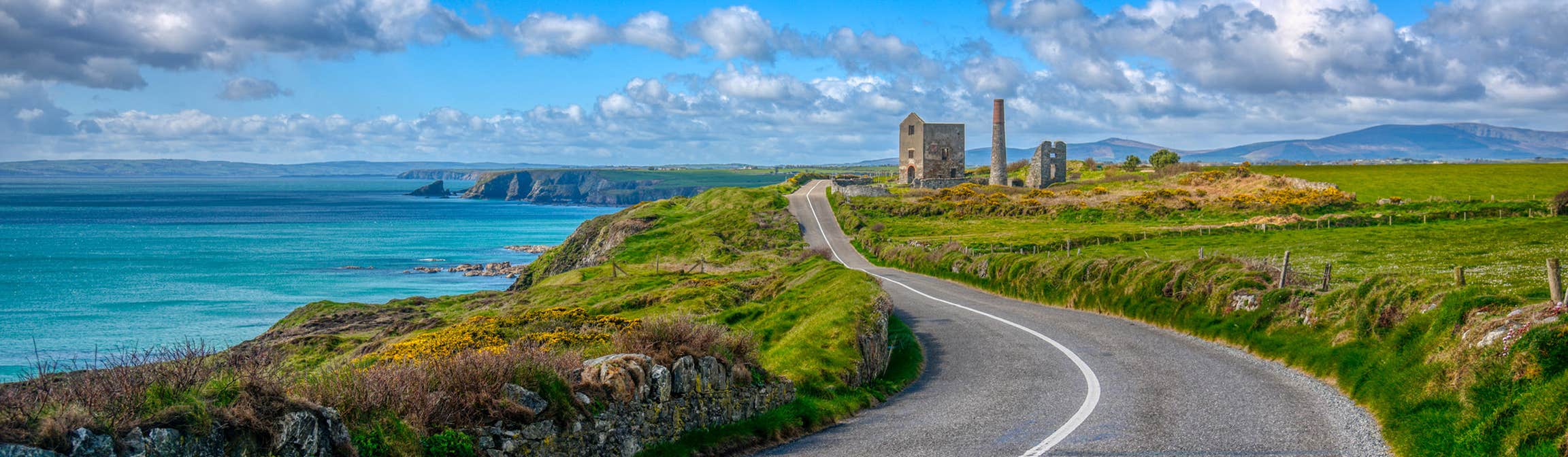 A country road beside a blue sea on the UNESCO Copper Coast, Waterford in Ireland's Ancient East.