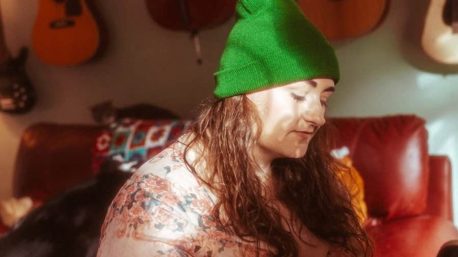 A woman in green wooly hat looking downwards.