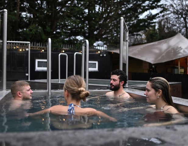 A group of people enjoying a cold plunge pool with The Hot Box Sauna Inchicore