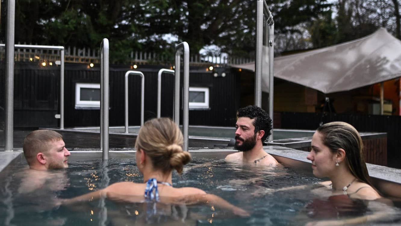A group of people enjoying a cold plunge pool with The Hot Box Sauna Inchicore