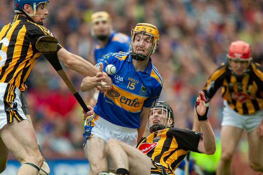 Three Kilkenny hurlers and two Tipperary players in action on the playing field