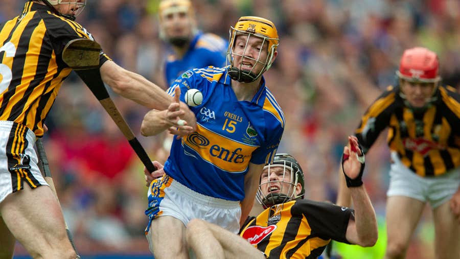 Three Kilkenny hurlers and two Tipperary players in action on the playing field