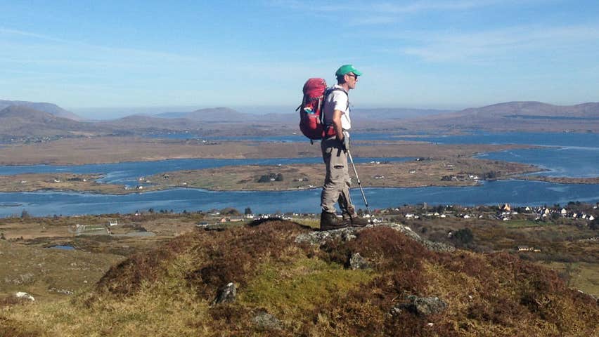 A man looking out over the sea from a hilltop view point