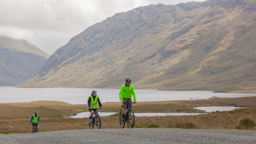 Two cyclists with a backdrop of magnificent mountain views