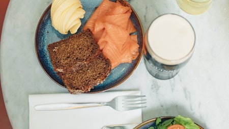 Flat lay view of marble table with two plates of seafood and one guinness and one beer