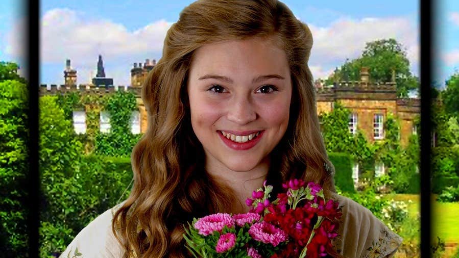 Title image of The Secret Garden, head and shoulders colourful photo of a teenage girl with wavy hair, smiling, holding a bunch of pink flowers, with a yellow coloured big old house in the background with bushes and hedges.