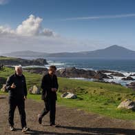 Director Martin Mc Donagh and actor Colin Farrell, are pictured walking on set of the 'The Banshees of Inisherin', with the peaks of Slievemore in the background.