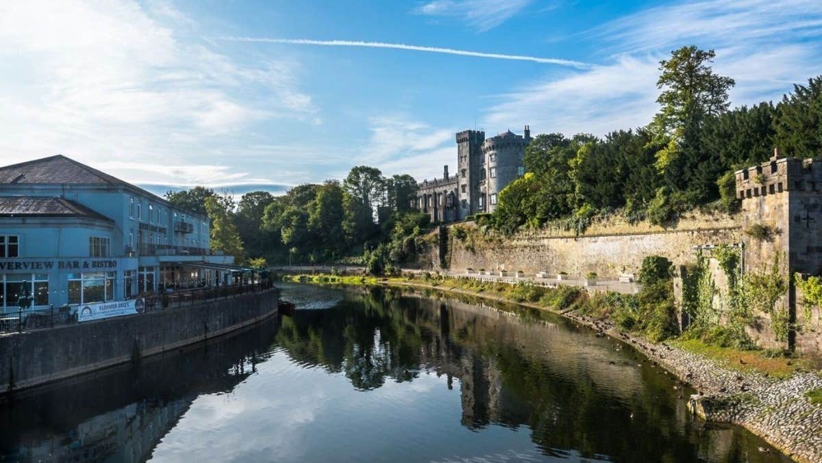 The exterior of a building with a terrace overlooking a river