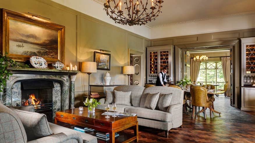 Grand living area in Ballynahinch Castle County Galway, with elegant furniture and large fireplace.
