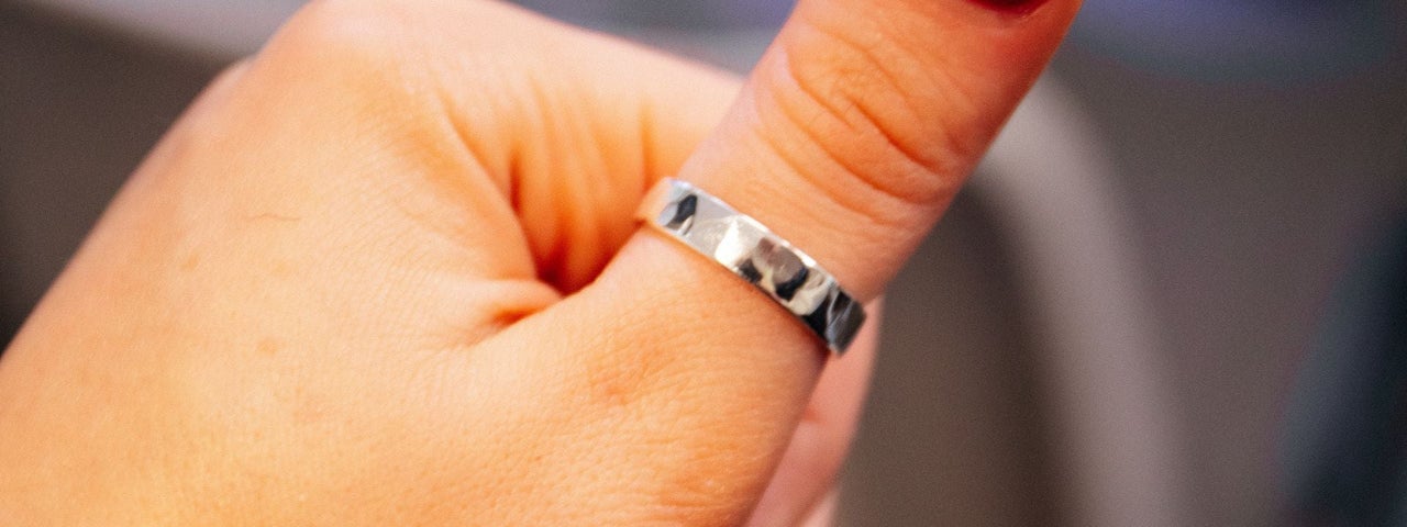 Silver ring on red nail varnished thumb at Silverworks
