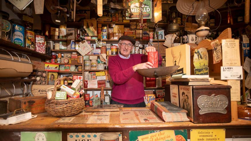 Man standing behind a counter weighing ingredients at Derryglad Folk and Heritage Museum in Roscommon