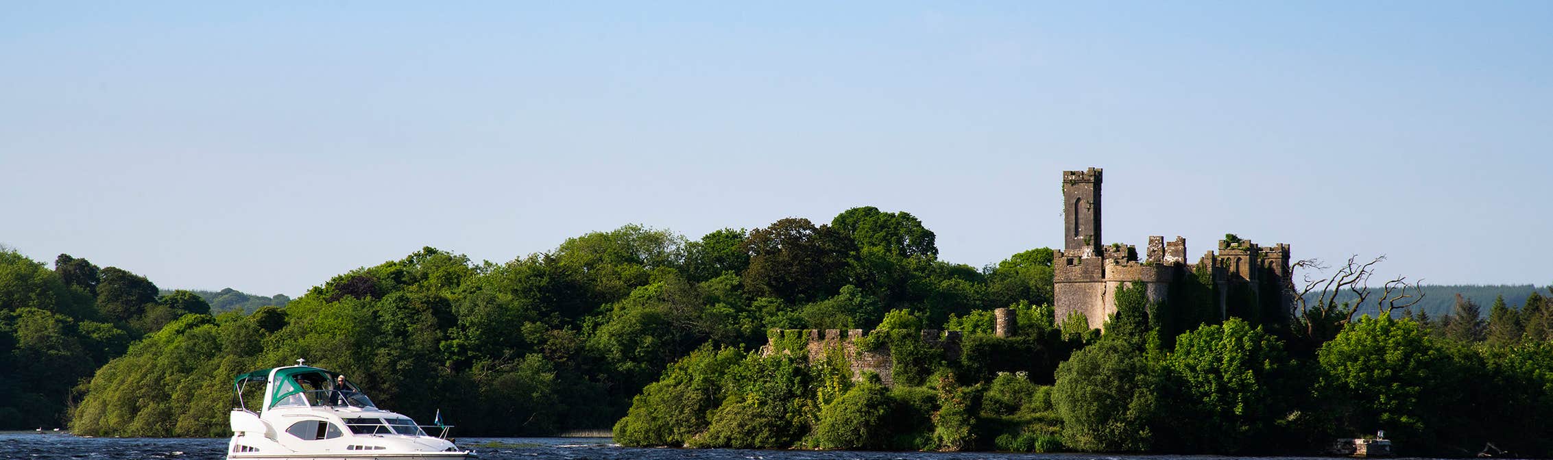 A boat sailing past a castle on Lough Key in Roscommon