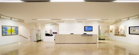 A reception desk in a gallery with artworks on the walls