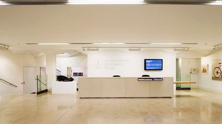 A reception desk in a gallery with artworks on the walls