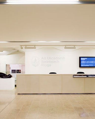 A reception desk in a gallery with artworks on the walls
