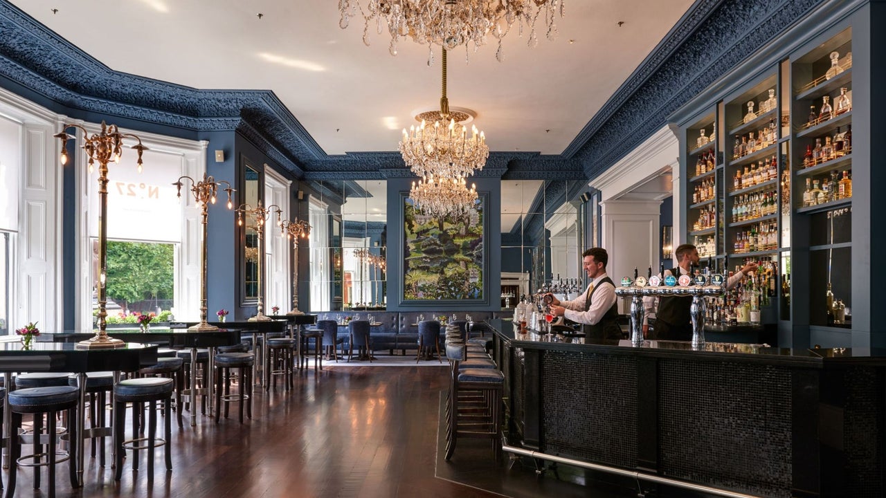 Elegant bar and lounge interior with chandeliers, mirrored walls and a well stocked bar