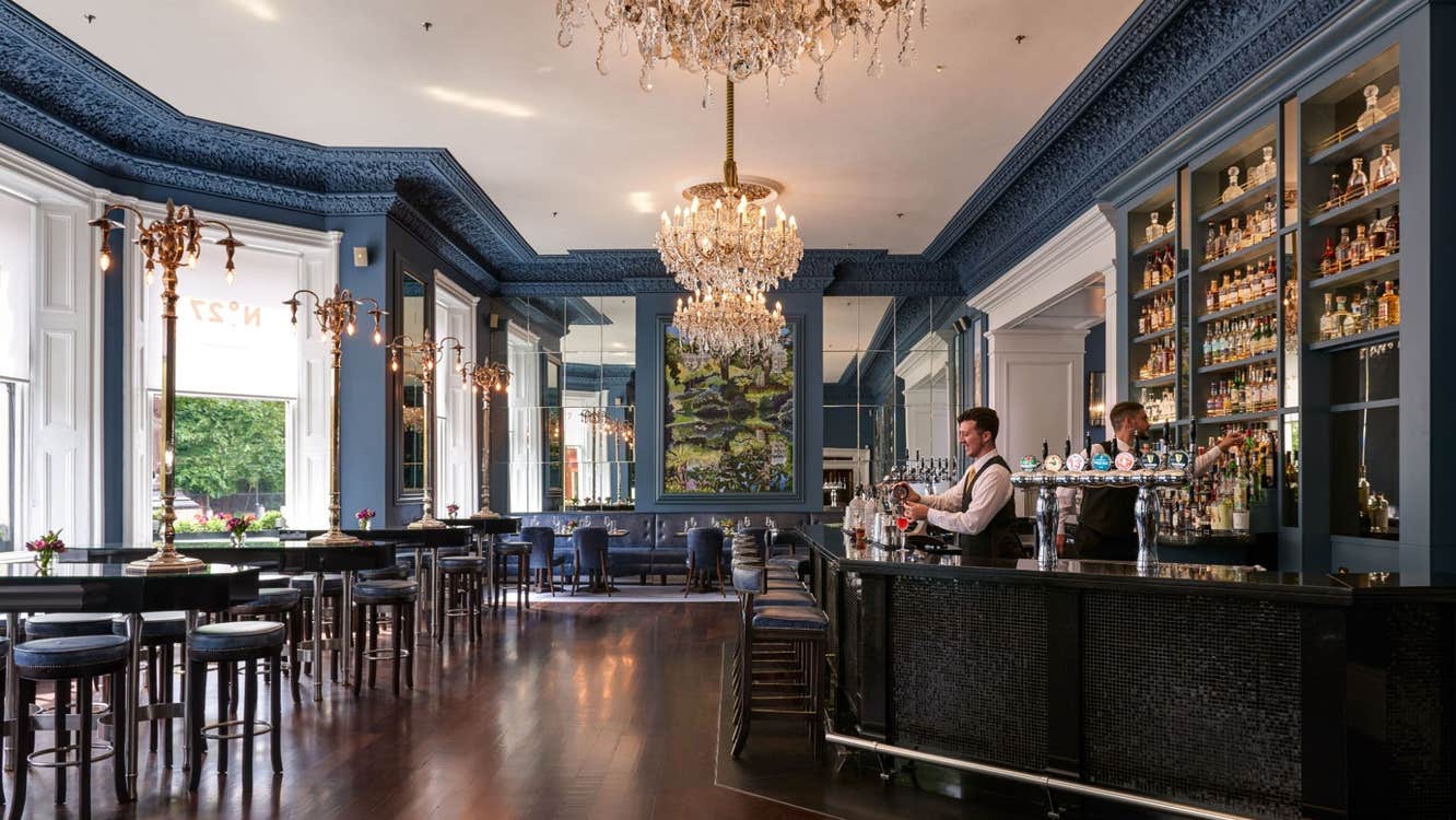 Elegant bar and lounge interior with chandeliers, mirrored walls and a well stocked bar