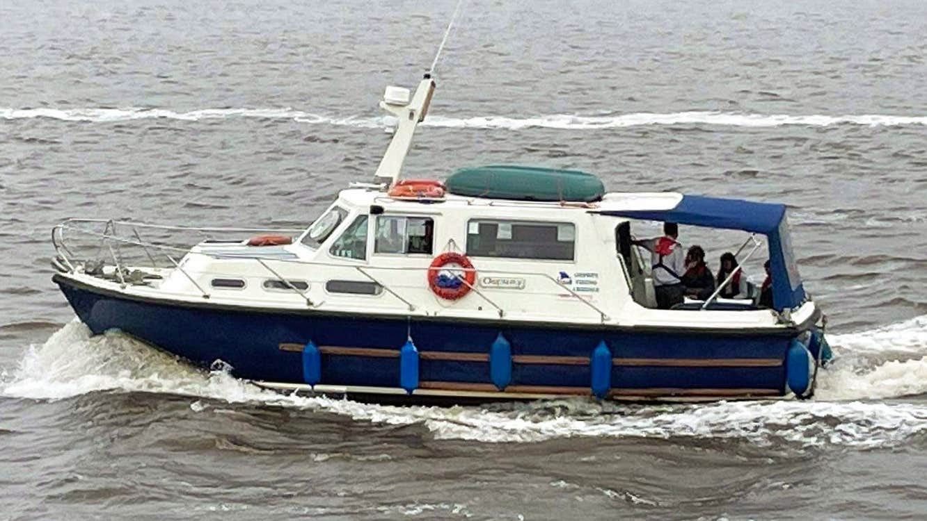Blue and white boat sailing on a grey sea