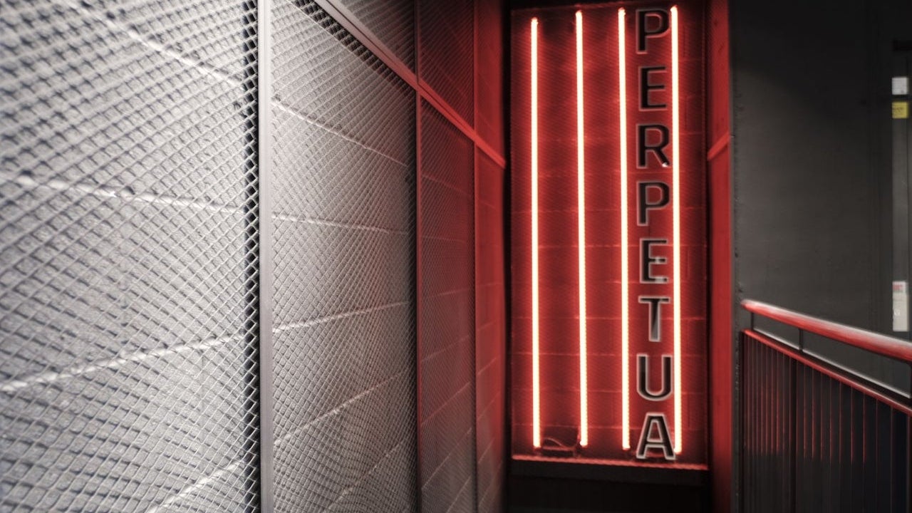 A neon lit corridor featuring Perpetua branding