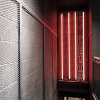 A neon lit corridor featuring Perpetua branding