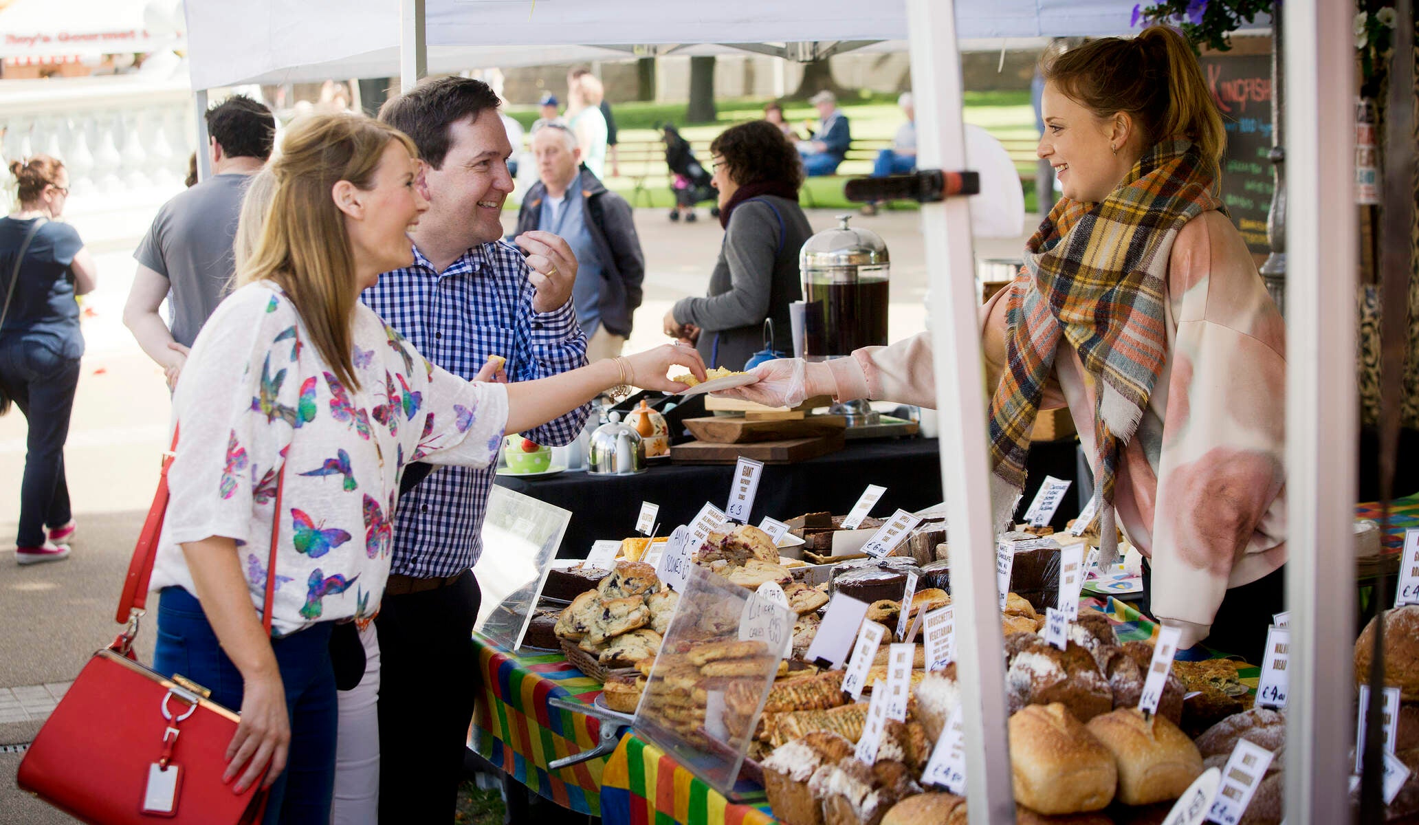 Image of people tasting food at a stall in the People's Park Market in Dun Laoghaire.