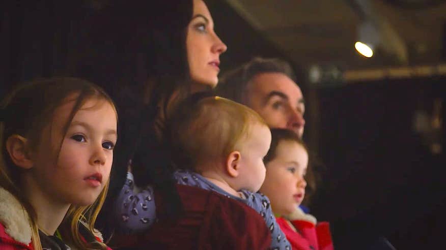 Picture of family looking past camera at an exhibit.