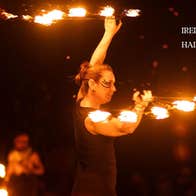 Skerries Fire Show Spectacular - a person at night is twirling around batons with the ends on fire.