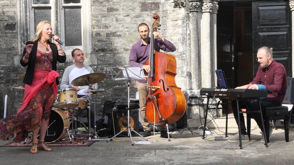 Small group of musicians performing in front of an old front door
