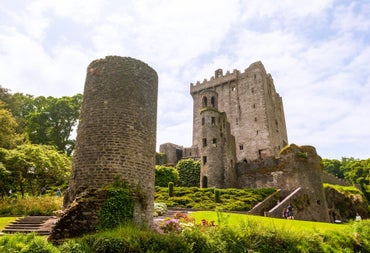 The ruins of a castle and a tower with people walking around the ruins