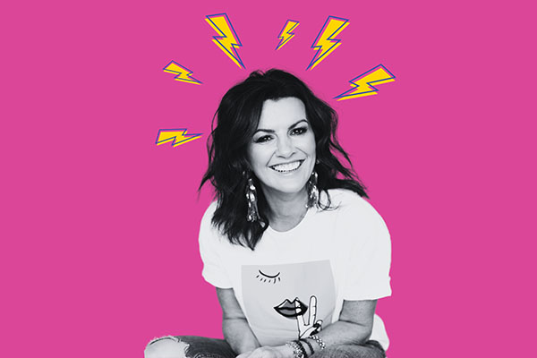 DEIRDRE O'KANE: DEMENTED at The Everyman, black and white photo of Deirdre smiling with pink background and yellow cartoon lightening bolts around her head