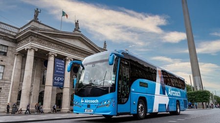 An Aircoach bus on a busy city street