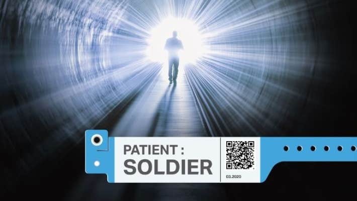 A dark tunnel with a silhouette of a figure walking down it towards a bright light