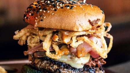 Gourmet burger topped with cheese bacon and crispy onions