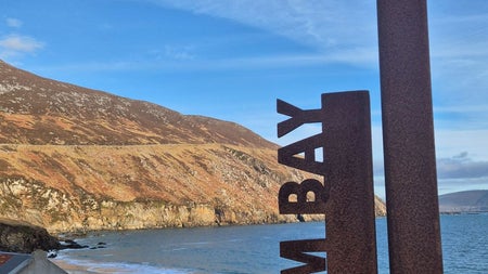 View of a brown road sign at Keem Bay on Achill Island with Wander Éire Tours