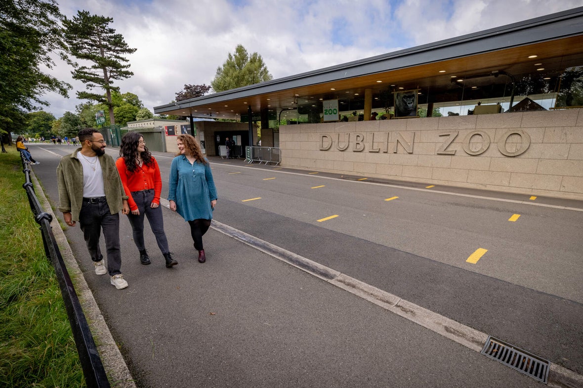 Three people walking into Dublin Zoo.