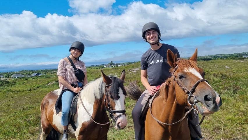 Two riders on horse back posing for the camera