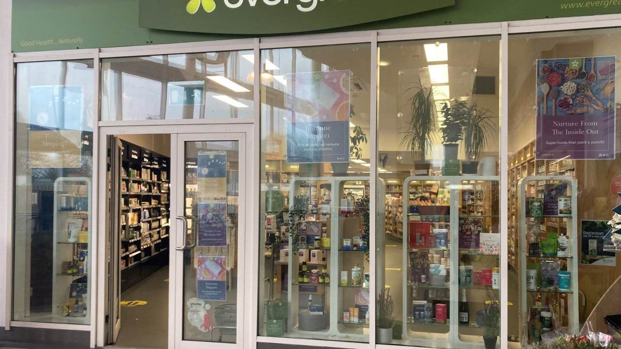 A shop exterior with floor to ceiling glass windows and lots of products on display