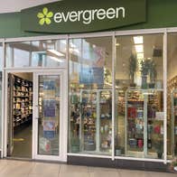 A shop exterior with floor to ceiling glass windows and lots of products on display