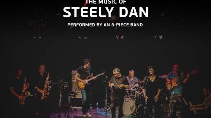 AJA - The Music of Steely Dan. Musicians playing on a darkly lit stage.