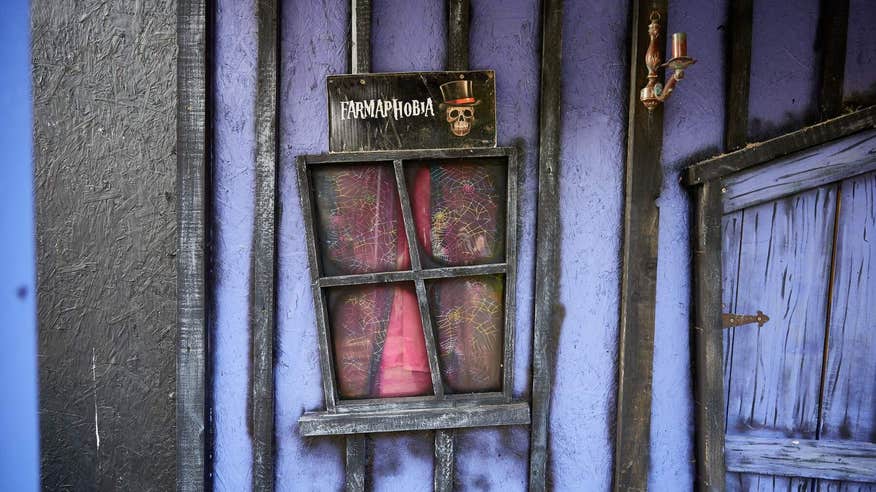 A sign at Causey Farm that says Farmaphobia with purple and black stripes and a skull with a top hat.