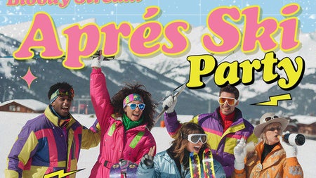 a group of people dressed in brightly coloured ski wear having fun with snowy mountains in background.