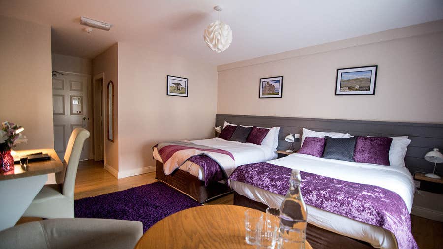 Twin bedroom with white and purple sheets