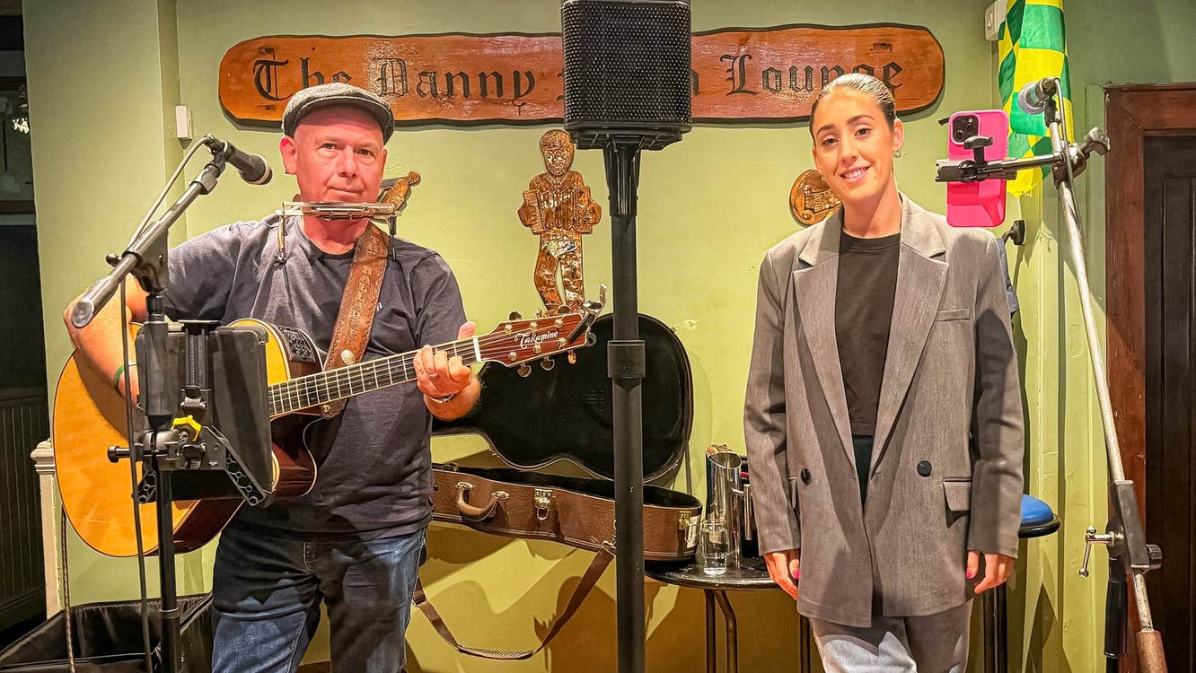 A guitar player and singer on a stage ready to perform