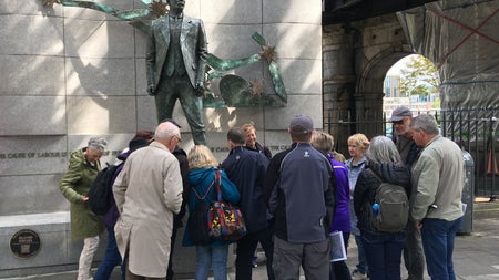 A tour group standing at a statue of James Connolly with a tour guide