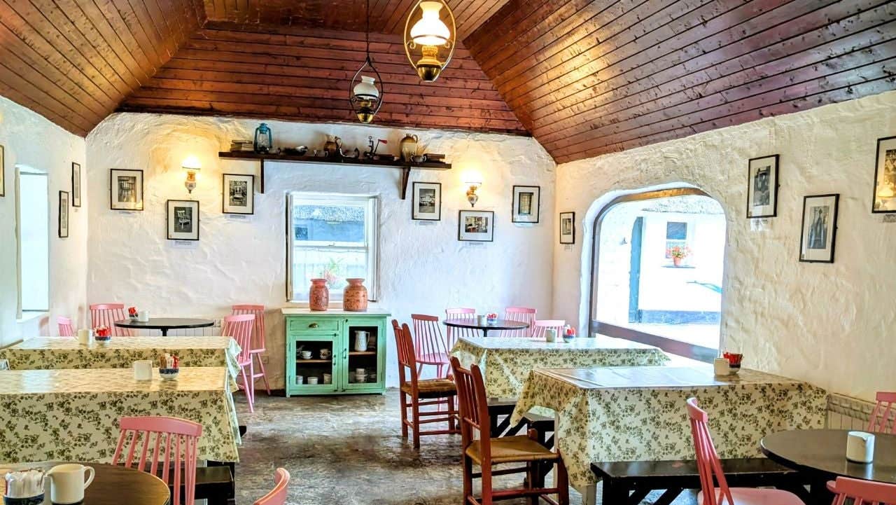 Rustic tea room interior with floral tablecloths and pastel chairs around small tables