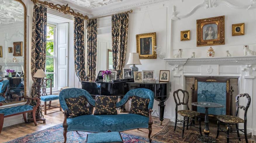 Interior of Huntington Castle in County Carlow with blue chairs and white walls.